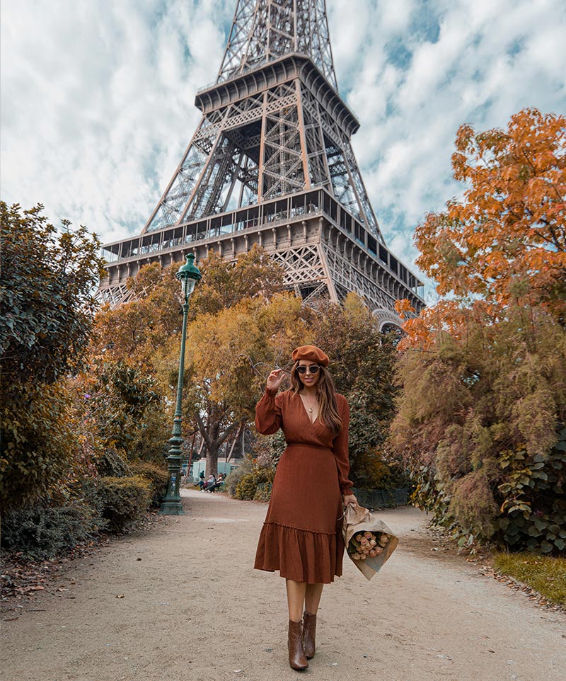 kelsey stood in front of eiffel tower surrounded by lots of orange autumn trees