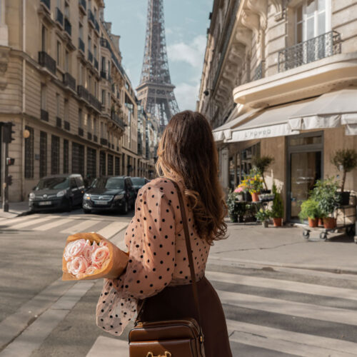 kelsey holding a bouqet of roses outside flower shop with eiffel tower view