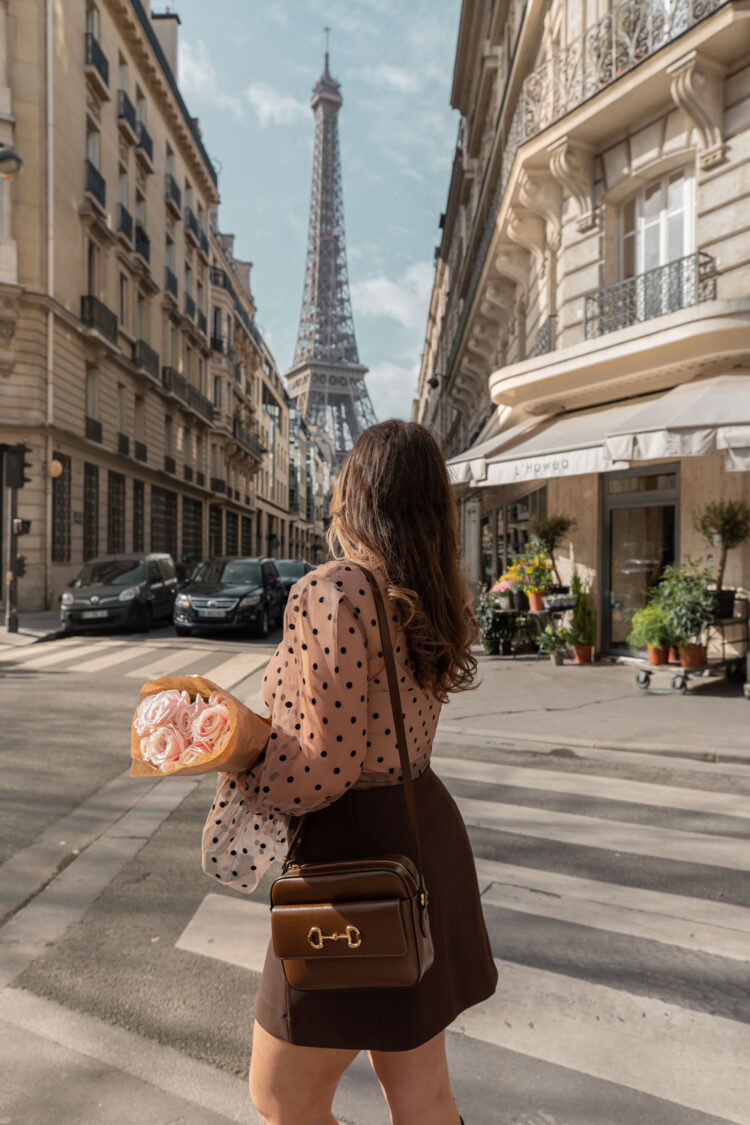 kelsey holding a bouqet of roses outside flower shop with eiffel tower view