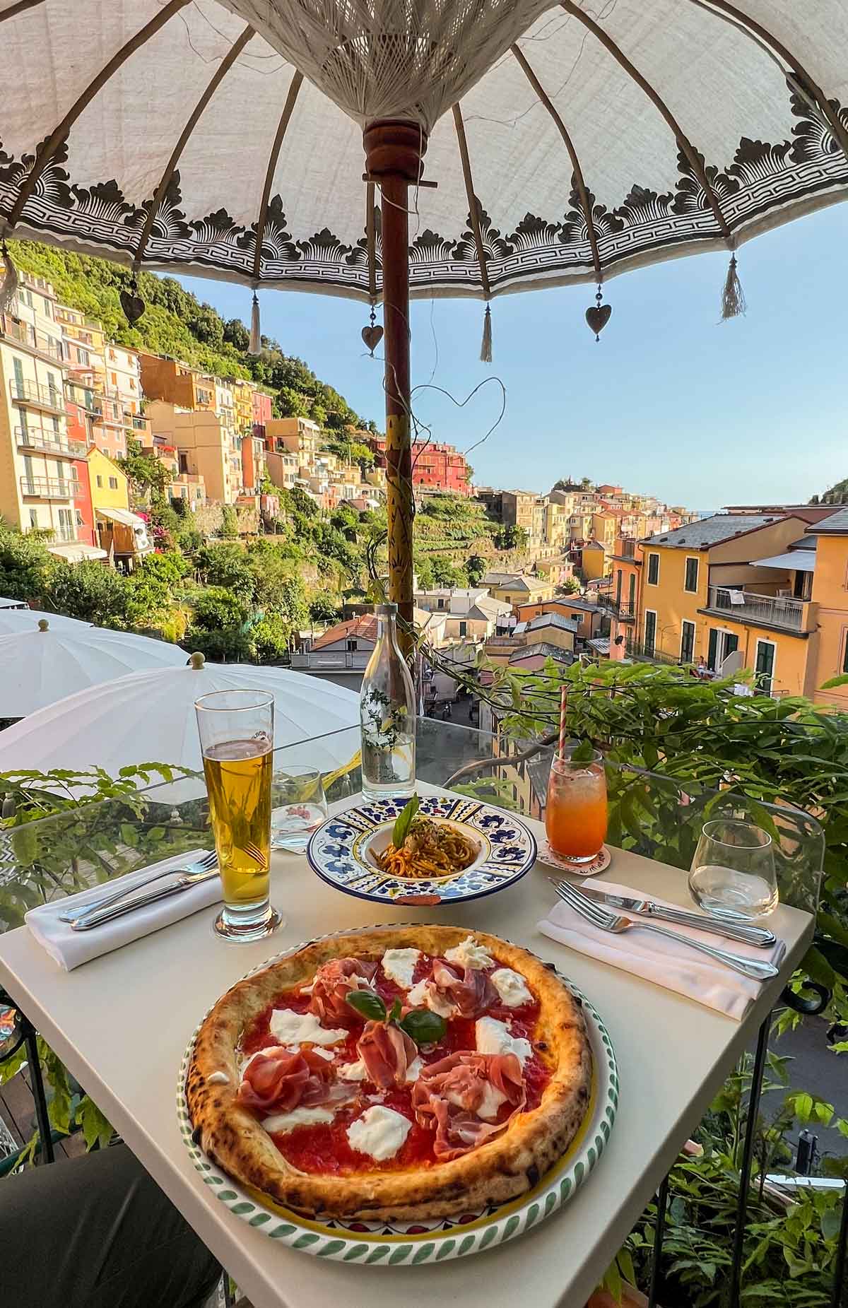 pizza and pasta with view of pastel coloured houses