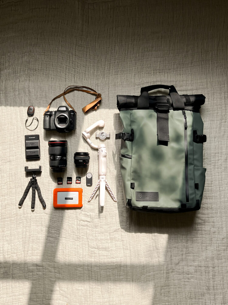 various cameras, lenses and accessories on top of a blanket