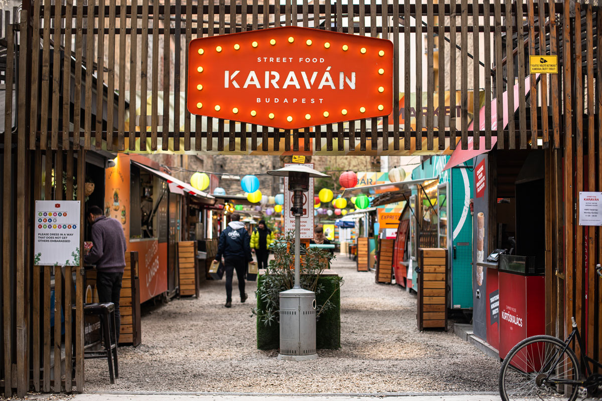 colourful street food market with bright orange sign that says Karavan
