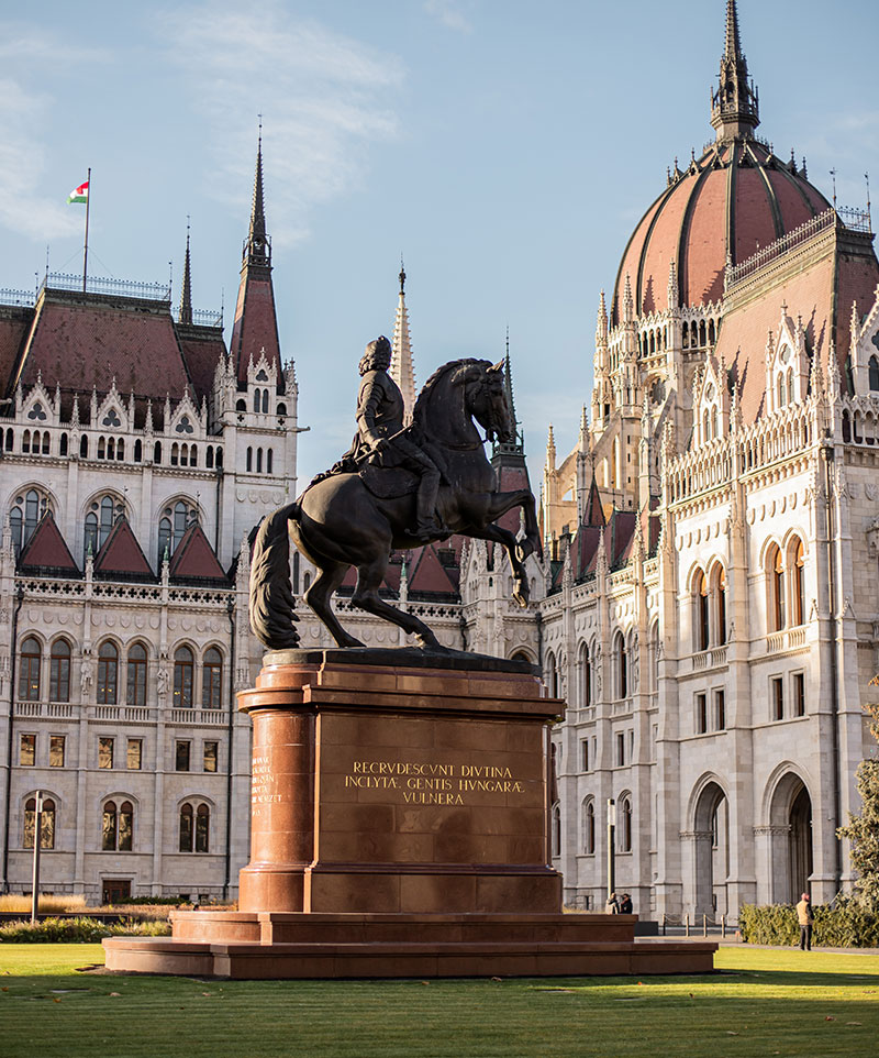 large statue of man riding horse outside neo gothic style Hungarian Parliament Building