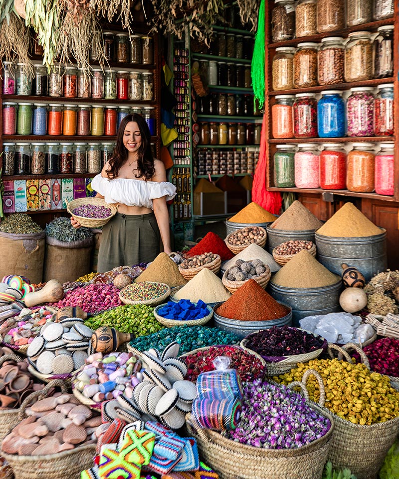 kelsey holding basket of lavander inside a colourful spice market stall